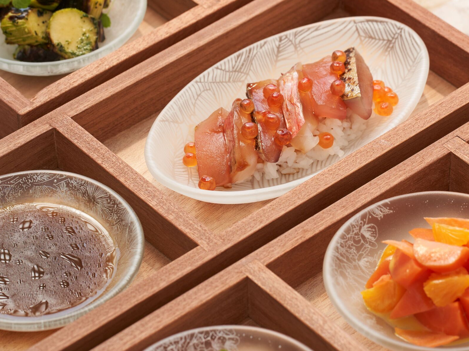 以木格托盤和玻璃餐盤裝盛的 Mory Sacko at Louis Vuitton 午餐餐點。