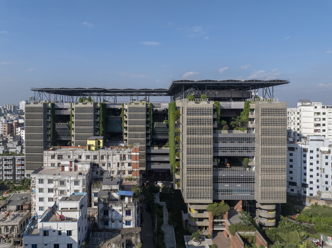 穿孔立面與綠植牆促進交叉通風與遮陽降溫。