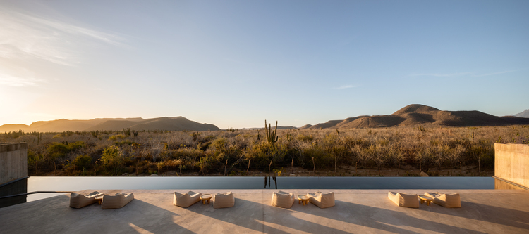 映照著夕陽和漠地風光的半月形露臺與無邊際泳池。