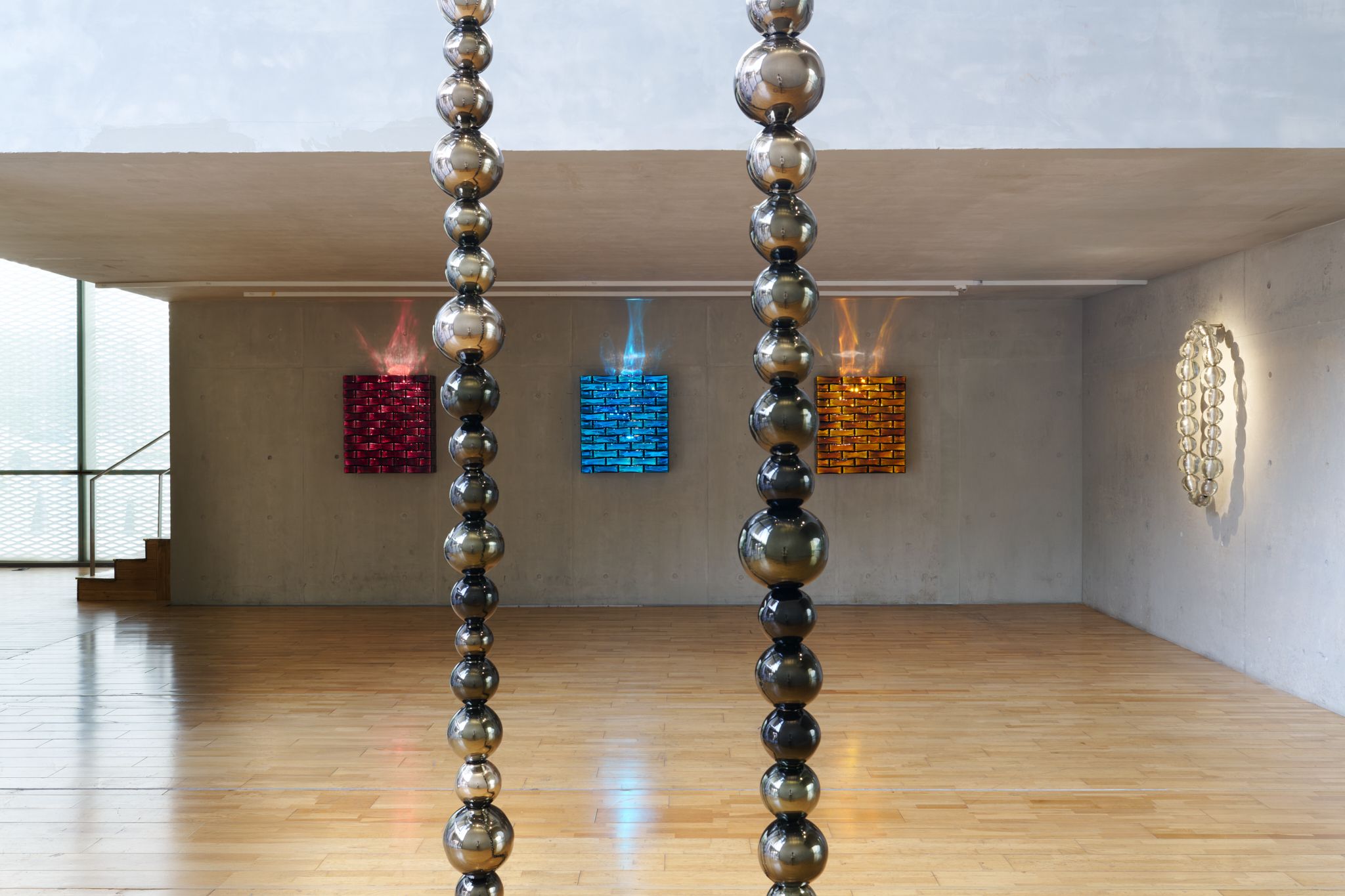 懸掛玻璃珠雕塑以節奏、重量與透明度變化， 展演珠寶與建築間的空間語彙。©Mengqi Bao / Perrotin